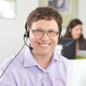 DATEV-Kundenservice-Mitarbeiter lächelt in die Kamera